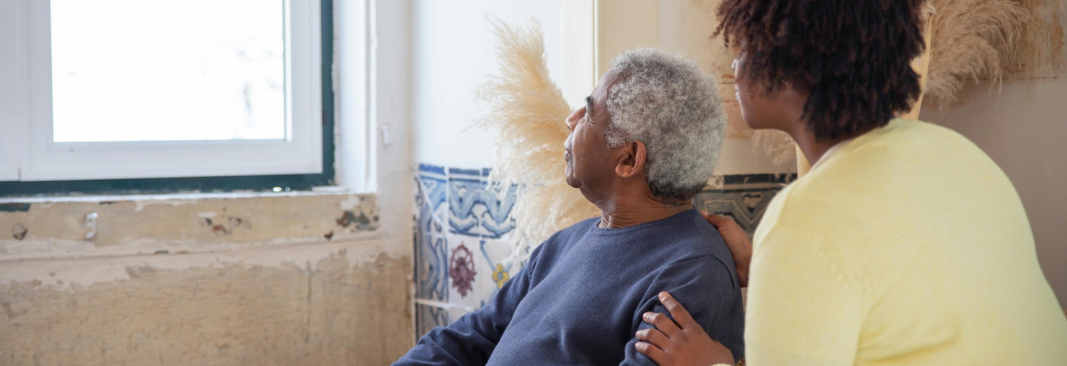 Elderly man and woman looking outside window