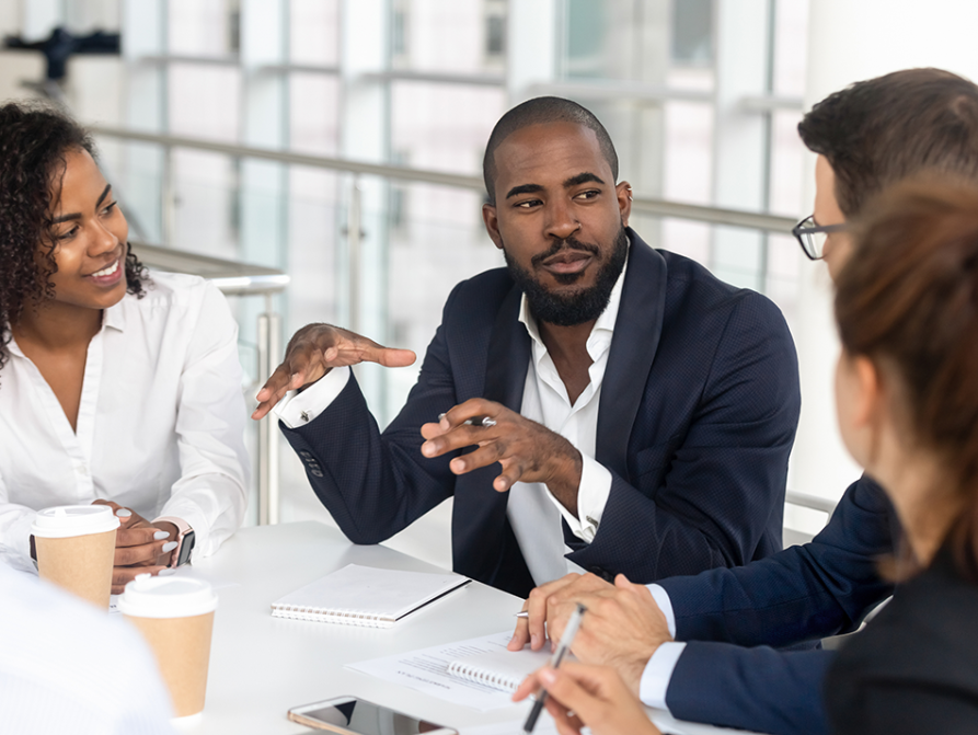IHI CQO Network Man at table meeting with other executives